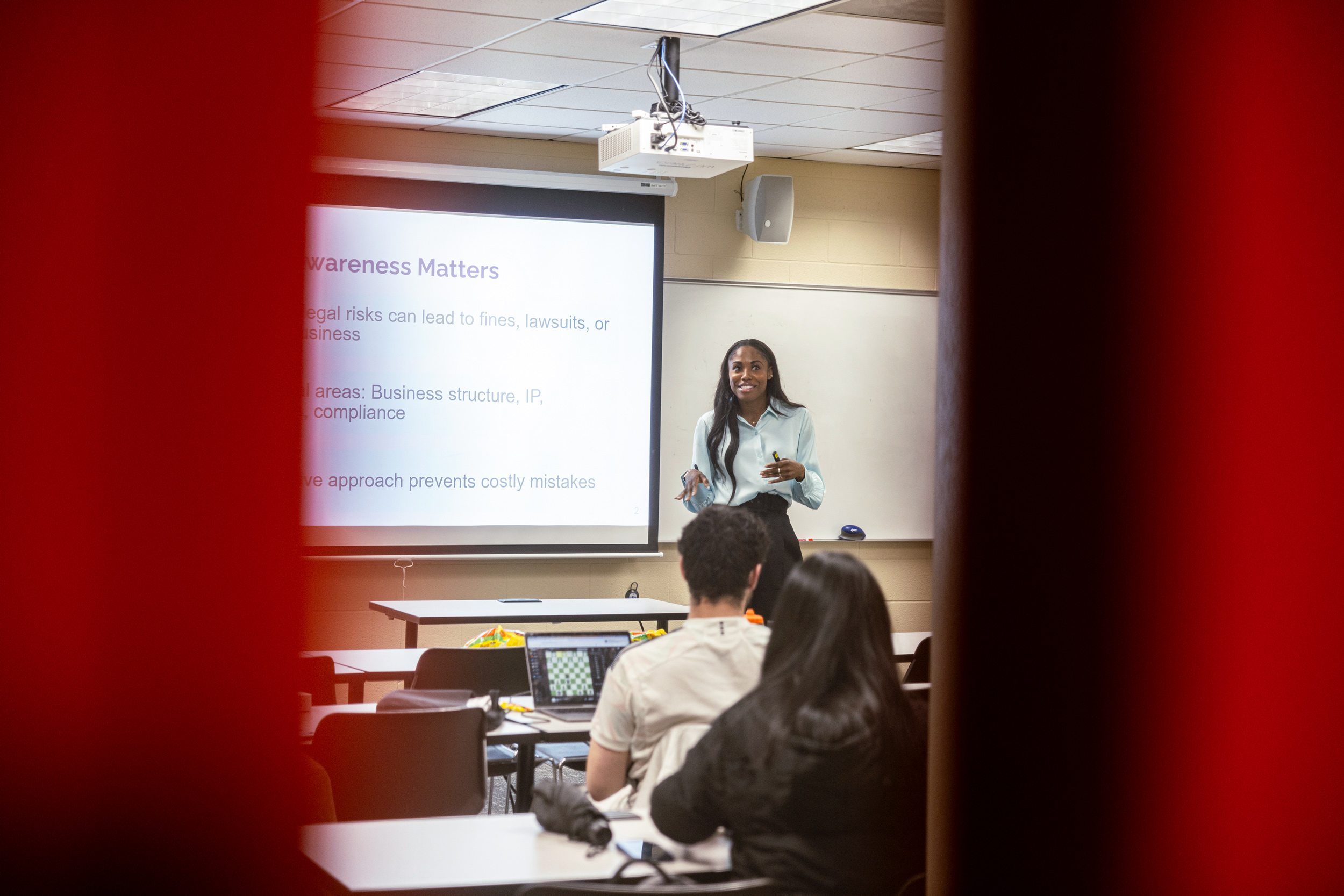 A photograph of Jasmine Ames presenting in front of a class of students